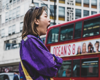 Woman tired and yawning in a street in London