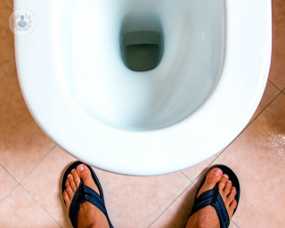 A man urinating into a toilet