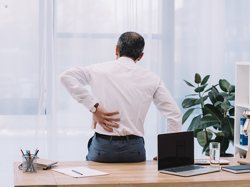 Man with sciatica holding his back