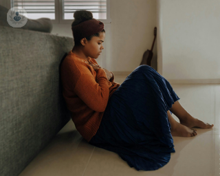 A young woman holding both hands to her chest, feeling anxiety