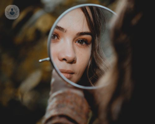 Woman looking in mirror after face reverse