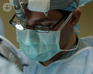 A surgeon in an operating theatre performing a polypectomy.