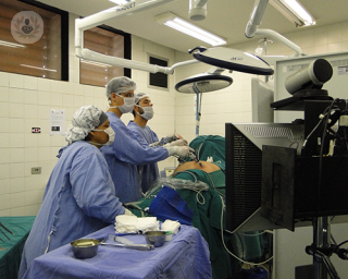 A group of surgeons in an operating theatre performing laparoscopic surgery.