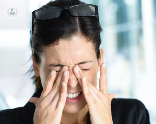 Woman holding her nose in pain