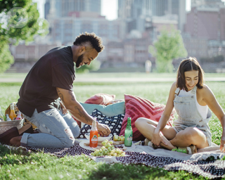 Man and woman enjoying a picnic with healthy food.