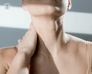 A person bares her throat to show off their Adam's apple