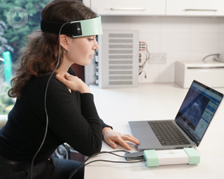 A girl with sensors attached to her head, undergoing a neurofeedback session.