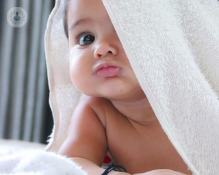 Baby with a towel on its head 