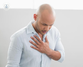 Man with chest pain holding his chest