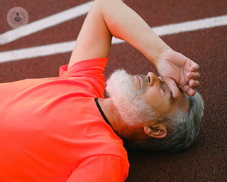 An elderly man lying on the floor, catching his breath