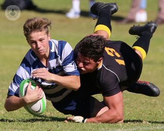 A team of adolescent players playing rugby