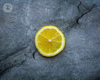 A lemon slice, laying on the ground.
