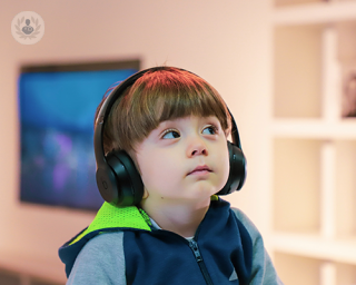 A child wearing headphones staring at the world around him