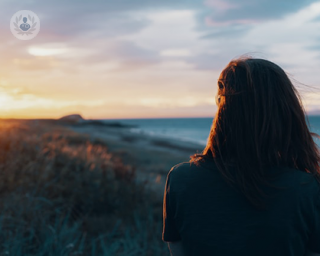 Woman looking at sea thinking about heavy periods