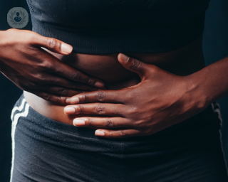 Woman with hernia holding stomach