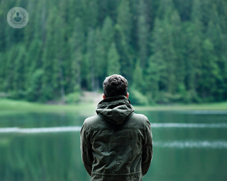 A man looking out into a lake.