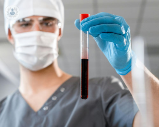 A doctor holds a test tube filled with blood