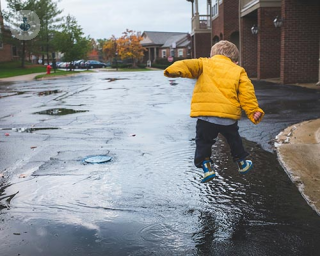 A little boy dancing in a puddle