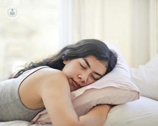 A young woman sleeping on her bed.