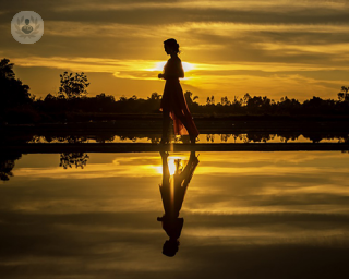 Woman walking by yellow lake