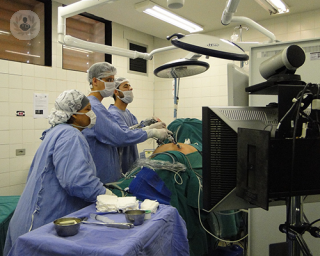 A surgeon in an operating theatre performing a minimally invasive surgery.
