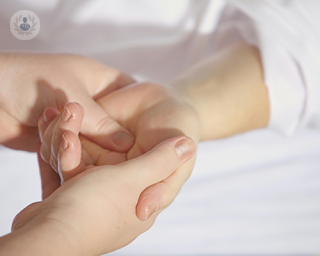 A patient's hand being examined by a doctor for signs of carpal tunnel syndrome.