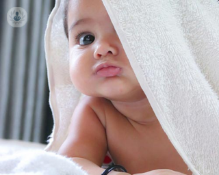 A baby with a towel on their head