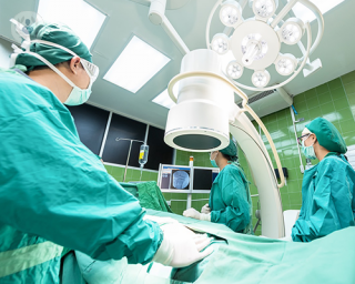 A group of surgeons in an operating theatre, performing a coronary angioplasty.