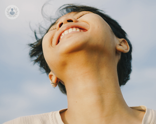 An upside up camera shot of a young woman, showing her elongated neck.