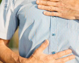 A man holding his hands on top of his chest and stomach, feeling pain