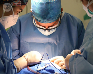A group of surgeons in an operating theatre, performing a coronary angioplasty.