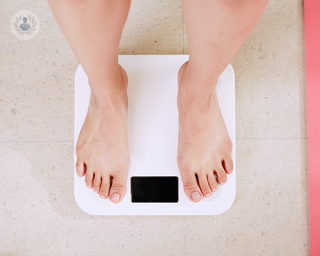 A person on top of a scale. The scale is blank and doesn't show the person's weight.