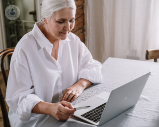 Elderly woman looking at her laptop