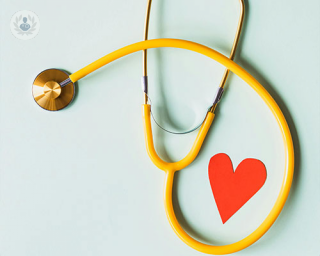 A yellow stethoscope next to a red paper heart