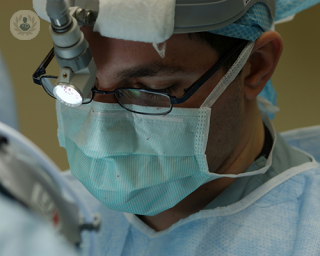 A surgeon in an operating theatre performing a reconstructive urological procedure.