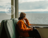 A woman contemplating the sea from a train.