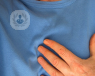 an image of a man in a blue jumper holding his heart