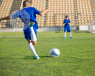 A boy playing football, about to score.