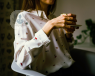 A hipster chick holding a tea and saucer