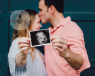 A couple showing an ultrasound scan of their unborn baby.