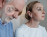 a woman and a man staring into space looking sad