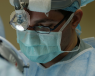 A surgeon in an operating theatre performing varicocele coil removal.