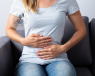 Woman sat down holding her stomach