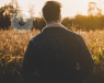 Man in denim jacket looking out over a field