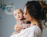 A mother holding and looking at her infant child, who could have infant feeding problems