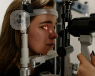 A young woman undergoing an eye examination of the front of her eyes.