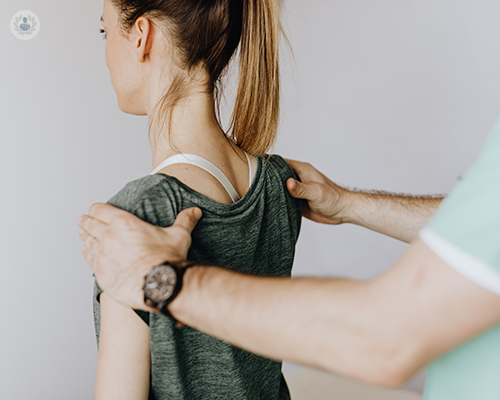 A patient undergoing a physical examination of her shoulders and rotator cuffs.