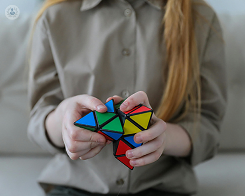 a girl trying to solve a rubix cube