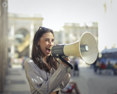 A woman protecting her voice by using a megaphone