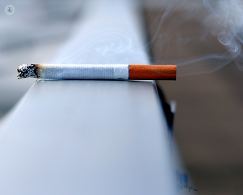 A picture of a lit cigarette that's been left and is smoking, a risk of DVT